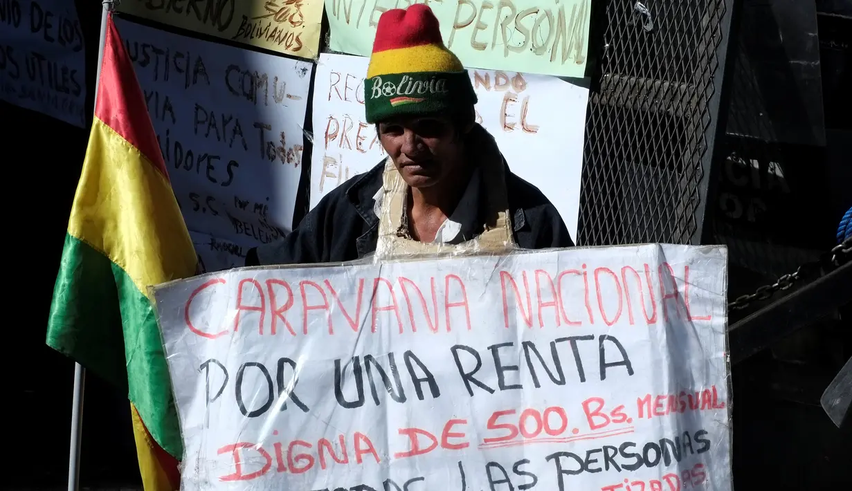 Seorang penyandang cacat membawa poster tuntutan saat ikut aksi di La Paz, Bolivia (3/5). Sejumlah wanita penyandang cacat nekat gantung diri saat aksi menuntut pemberian subsidi dari pemerintah. (REUTERS/David Mercado)