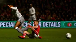 Striker Manchester United, Marcus Rashford merebut bola dari gelandang Bristol City, Jamie Paterson pada perempat final Piala Liga Inggris di Ashton Gate, Kamis (21/12). MU gagal melangkah ke babak empat besar setelah kalah 1-2. (Geoff CADDICK / AFP)