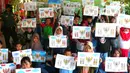 Anak-anak menunjukkan karyanya mewarnai burung garuda di Kampung Tematik Kampung Teras Pancasila, Karang Tengah, Tangerang, Banten, Rabu (1/6/2022). Kegiatan tersebut dilaksanakan dalam rangka memperingati hari lahirnya Pancasila bertujuan untuk memberikan wawasan dan pengetahuan tentang nilai-nilai Pancasila sejak dini. (Liputan6.com/Angga Yuniar)