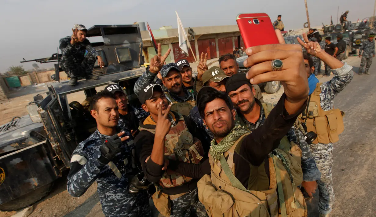 Sejumlah pasukan Irak berselfie di Qayyara saat berusaha merebut kembali kota Mosul dari tangan kelompok militan ISIS di Irak, (26/10). (REUTERS/Alaa Al-Marjani)