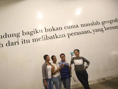 Pengunjung berfoto di depan mural bertema Kota Bandung di Jalan Asia Afrika, Bandung, Jawa Barat, Selasa (5/7). Dua buah mural tersebut menjadi lokasi favorit bagi warga dan wisatawan di Bandung untuk berfoto. (Liputan6.com/Immanuel Antonius)