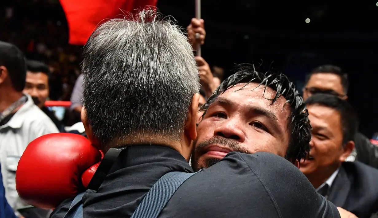 Petinju Filipina Manny Pacquiao merayakan kemenangannya usai melawan petinju Argentina, Lucas Matthysse pada kelas welter versi WBA di Axiata Arena di Kuala Lumpur, Malaysia (15/7). Pacquiao menang KO atas Matthysse di Ronde ke 7. (AFP Photo/Mohd Rasfan)