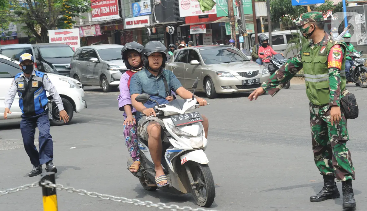 Petugas memberhentikan pengendara yang tidak mengenakan masker saat razia pelanggar PSBB di Jalan Raya Cinere, Depok, Jawa Barat, Senin (24/8/2020). Pelanggar PSBB Kota Depok yang saat ini kembali menjadi zona merah mendapat hukuman sosial atau denda. (merdeka.com/Arie Basuki)