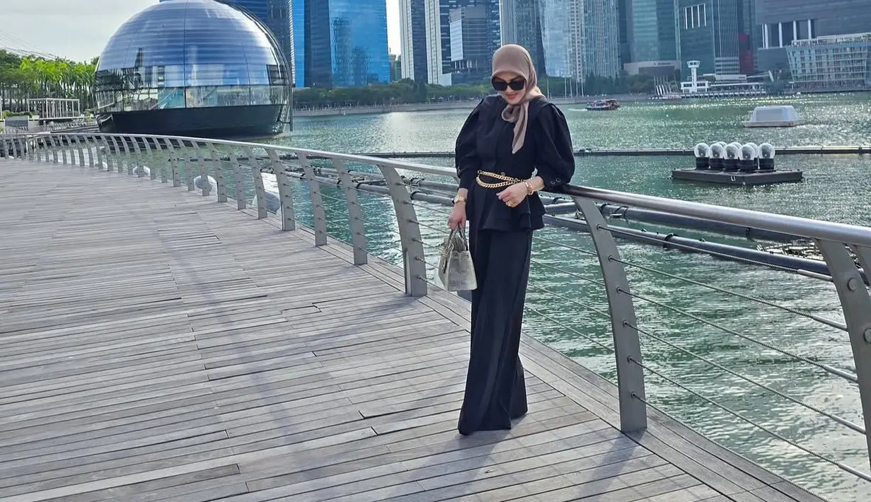 Penampilannya dilengkapi kerudung coklat dan belt model rantai gold. Tas Hermes abu-abu pun digenggamannya. [@princessyahrini]