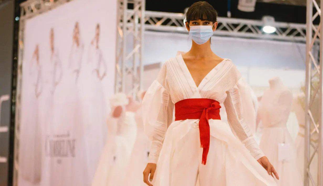 Seorang model yang mengenakan masker memperagakan gaun pengantin di pameran dagang European Bridal Week di Essen, Jerman, pada 5 Juli 2020. European Bridal Week, sebuah pameran dagang internasional tentang pernikahan, diselenggarakan mulai 4 hingga 6 Juli. (Xinhua/Tang Ying)