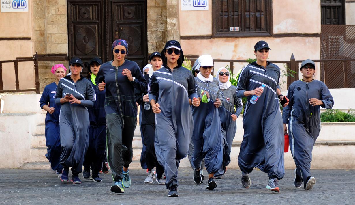 Perempuan Arab Saudi jogging memperingati Women's Day atau Hari Perempuan Internasional di jalanan Distrik Al-Balad, Jeddah, Kamis (8/3). Aksi ini untuk pertama kalinya Hari Perempuan Internasional dilakukan di Arab Saudi. (Amer HILABI/AFP)