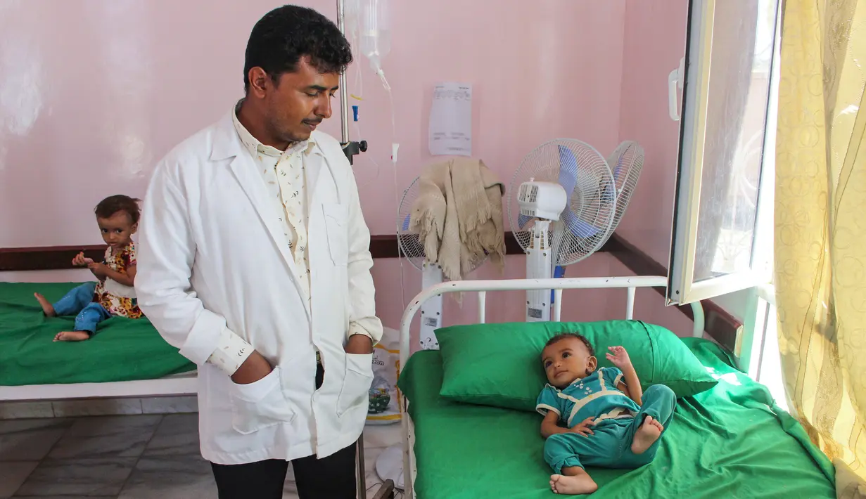Dokter melihat kondisi anak yang menderita gizi buruk di rumah sakit di Distrik Abs, Provinsi Haji, Yaman, Rabu (19/9). Menurut LSM Save the Children, 5,2 juta anak Yaman berisiko kelaparan karena tidak mampu membeli makanan dan air. (ESSA AHMED/AFP)