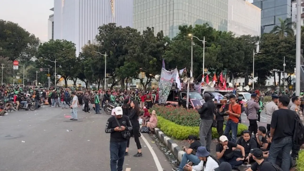 Massa demonstrasi ojek online atau ojol di Patung Kuda kawasan Monumen Nasional (Monas), Jakarta Pusat menyudahi penyampaian aspirasinya dan mulai membubarkan diri, Selasa (20/5/2025). (Liputan6.com/Nanda Perdana Putra)