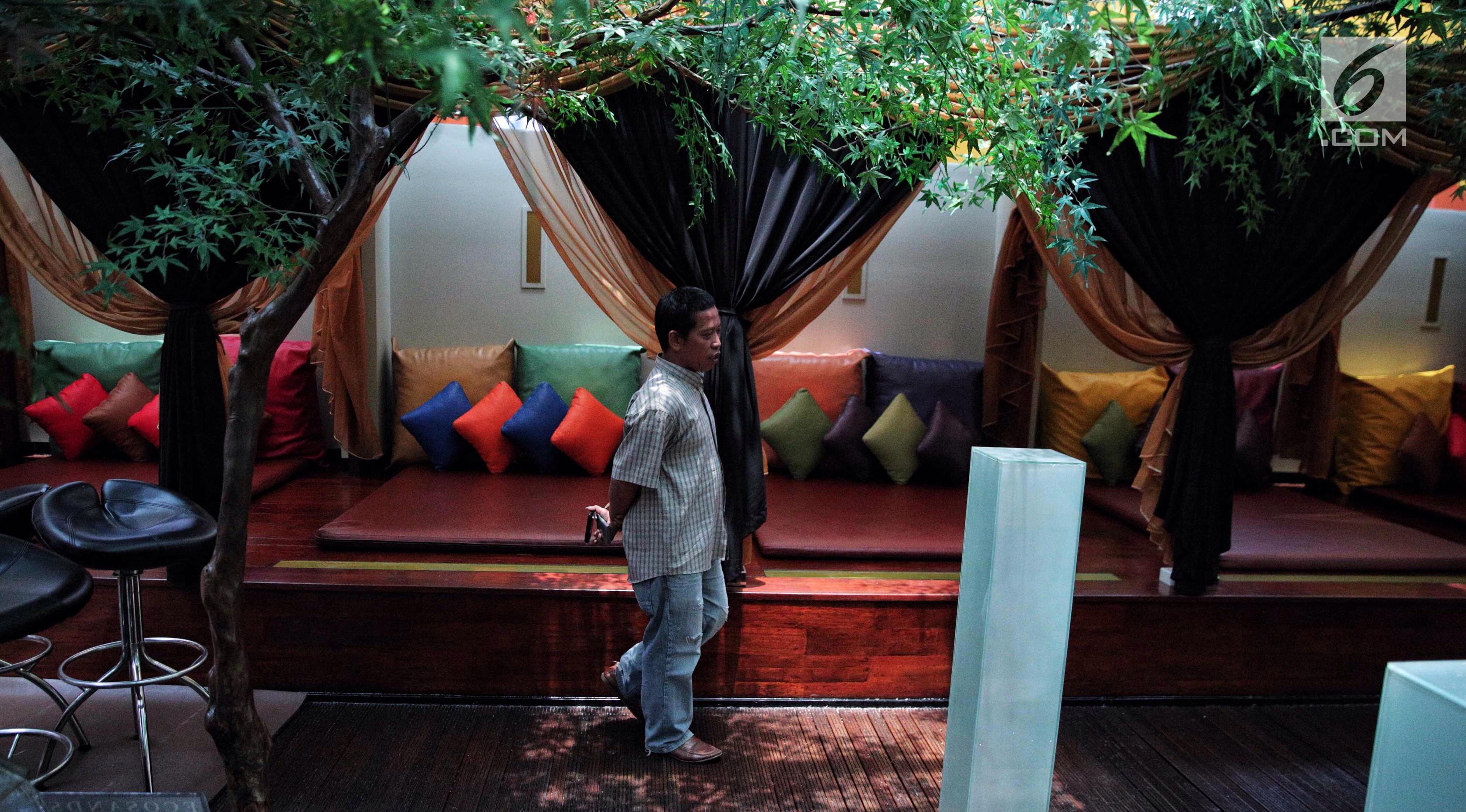 Seorang pria melintas di depan gazebo dengan penutup di lantai tujuh Hotel Alexis, Jakarta, Selasa (31/10). Gazebo panjang itu bisa dipisahkan dengan tirai-tirai dan dilengkapi matras dan aneka bantal warna-warni. (Liputan6.com/Faizal Fanani)