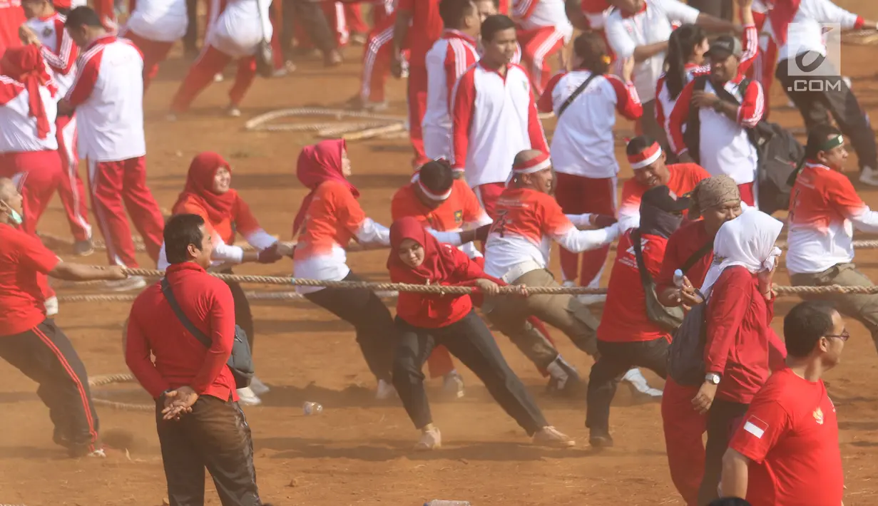 Aparatur Sipil Negara (ASN) Kementerian Dalam Negeri menarik lawan dalam lomba tarik tambang di Lapangan Banteng, Jakarta, Jumat (2/8/2019). Kemendagri bersama Badan Pengelola Nasional Pengelola Perbatasan (BNPP) memecahkan rekor MURI yang diikuti sebanyak  1.200 peserta. (Liputan6.com/Angga Yuniar)