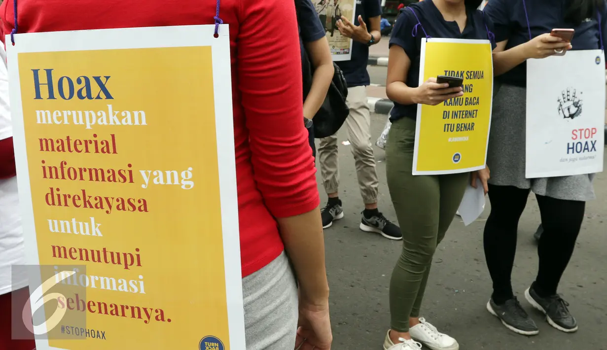 Sejumlah orang yang tergabung dalam Masyarakat Anti Fitnah Indonesia (Mafindo) membentangkan spanduk dan poster di hari bebas kendaraan bermotor di kawasan Thamrin, Jakarta, Minggu (22/1). (Liputan6.com/JohanTallo)