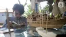 Perajin menyelesaikan pembuatan miniatur kapal pinisi yang terbuat dari limbah bambu di Pondok Benda, Pamulang, Tangerang Selatan, Senin (09/11/2020). Kerajinan berbahan bambu bekas yang dijual dengan harga berkisar Rp.50 ribu hingga Rp.250 ribu tergantung ukurannya. (merdeka.com/Dwi Narwoko)