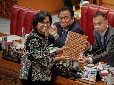 Menteri Keuangan Sri Mulyani menyerahkan berkas kepada Wakil Ketua DPR RI Sufmi Dasco Ahmad saat Rapat Paripurna DPR RI Ke-23 Masa Persidangan V Tahun 2022-2023 di Nusantara II, Kompleks Parlemen MPR/DPR-DPD, Senayan, Jakarta, Selasa (30/5/2023). Rapat paripurna ini membahas Tanggapan Pemerintah terhadap Pandangan Fraksi atas Kerangka Ekonomi Makro dan Pokok- Pokok Kebiiakan Fiskal (KEM dan PPKF) RAPBN Tahun Anggaran 2024. (Liputan6.com/Faizal Fanani)