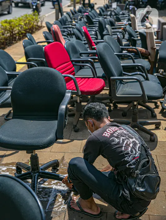 Karyawan membersihkan peralatan kantor pascabanjir di salah satu bank swasta di Kemang, Jakarta, Selasa (23/2/2021). Karyawan pertokoan, perkantoran, hingga perbankan mulai membersihkan sisa lumpur dari banjir yang melanda kawasan tersebut pada 20 Februari 2021 lalu. (Liputan6.com/Faizal Fanani)