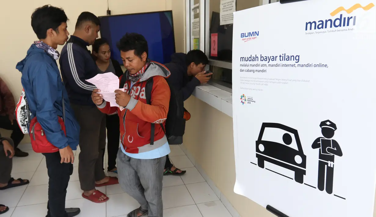 Warga mengantre untuk transaksi pembayaran tilang online di kantor Kejaksaan Negeri Jakarta Pusat, Jakarta, Kamis (3/1). Pembayaran tilang online ini melalui saluran pembayaran elektronik seperti ATM dan Mandiri Online. (Liputan6.com/Angga Yuniar)