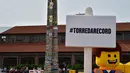 Karakter Lego berpose  di depan sebuah menara lego setinggi 35.50 meter, Itali, Minggu (21/6/2015).  Menara ini dibangun oleh ribuan relawan menggunakan sekitar 580.000 lego dan mendapat sertifikat rekor dunia dari Guinness. (AFP Photo/Giuseppe Cacace) 