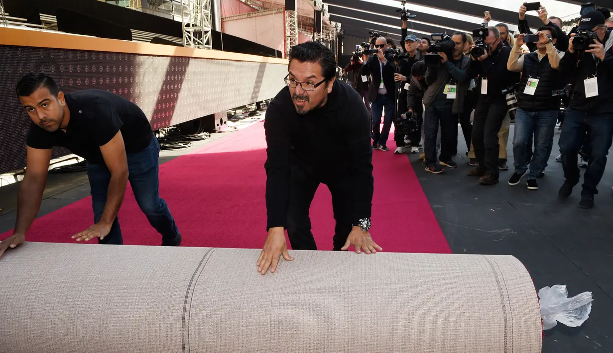 Petugas memasang karpet merah Academy Awards ke-90 di Dolby Theatre, Rabu (28/2). Piala Oscar yang biasa diselenggarakan akhir Februari ini diadakan awal Maret untuk menghindari bentrok dengan Olimpiade Pyeongchang 2018. (Chris Pizzello/Invision/AP)