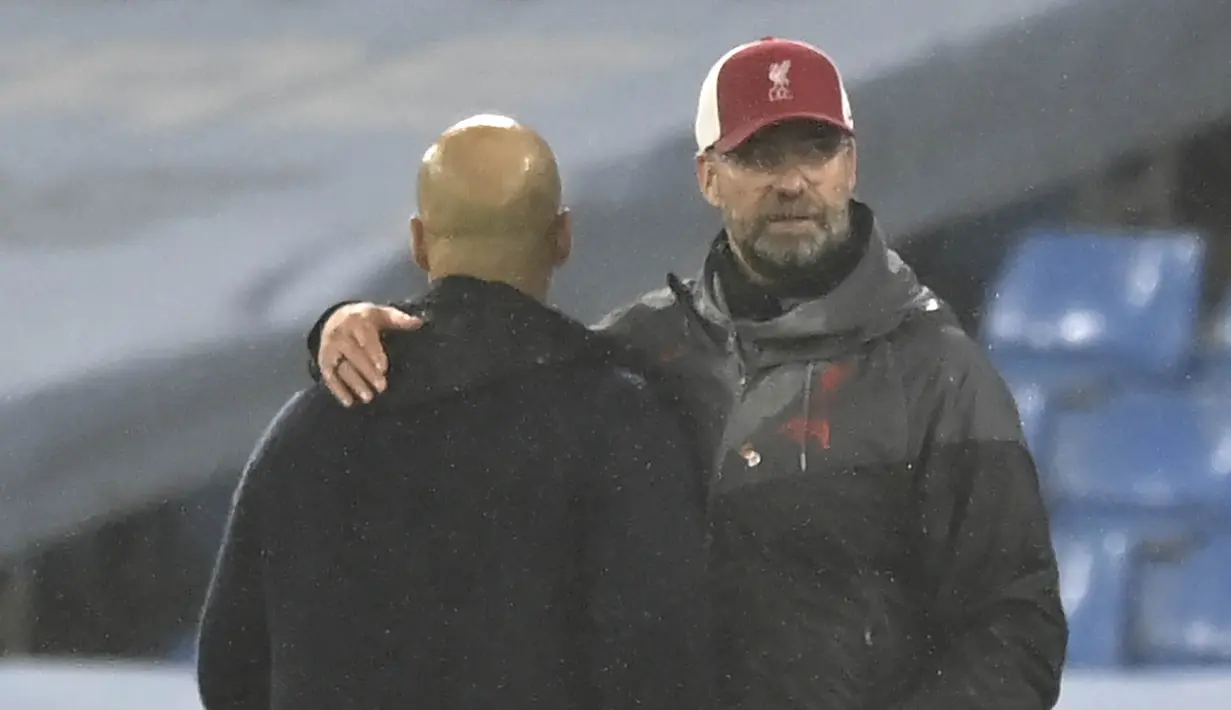 Pelatih Liverpool, Jurgen Klopp, merangkul pelatih Manchester City, Pep Guardiola, pada laga Liga Inggris di Stadion Etihad, Minggu (8/11/2020). Kedua tim bermain imbang 1-1. (Martin Rickett/Pool via AP)
