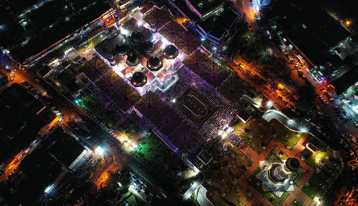 Banyaknya orang yang ingin menunaikan ibadah sholat tarawih sudah tampak dari setiap pintu masuk masjid. (CHAIDEER MAHYUDDIN/AFP)