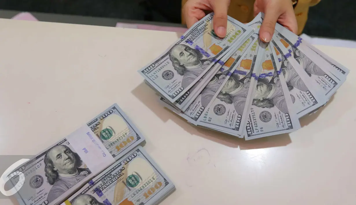 Petugas tengah menata mata uang dolar di Jakarta, Rabu (13/9). Dolar AS mulai menguat terhadap rupiah. (Liputan6.com/Angga Yuniar)