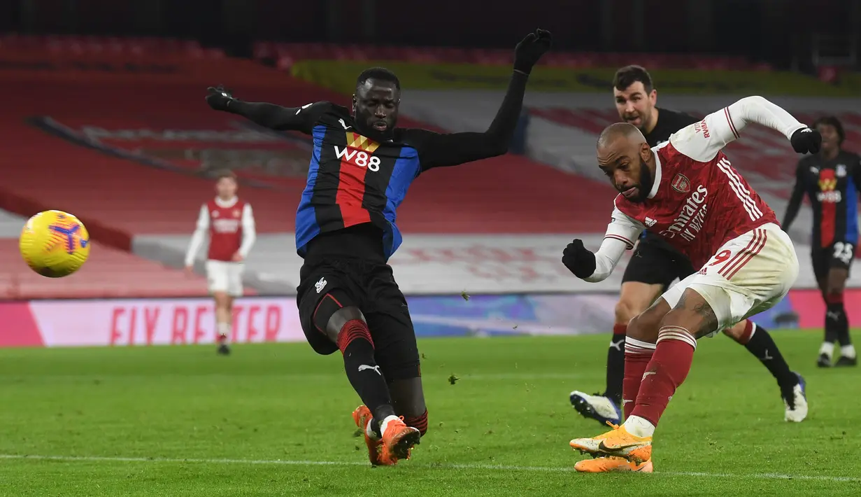 Striker Arsenal, Alexandre Lacazette (kanan) melepaskan tendangan ke gawang Crystal Palace dalam laga lanjutan Liga Inggris 2020/21 di Emirates Stadium, Kamis (14/1/2021). Arsenal bermain imbang 0-0 dengan Crystal Palace. (AFP/Neil Hall/Pool)