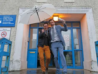 Richard Dowlin (kiri) dan Cormac Gollogly usai melangsungkan pernikahan di kantor the South Clonmel Community Care Centre di Irlandia, (17/11/2015). Dowlin dan Gollogly adalah pasangan gay pertama yang menikah di Irlandia. (REUTERS/Cathal McNaughton)