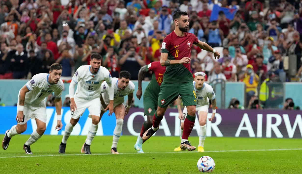 Bruno Fernandes. Gelandang serang Timnas Portugal berusia 28 tahun ini sukses membuat satu gol lewat eksekusi penalti di Piala Dunia 2022 pada matchday kedua Grup H menghadapi Timnas Uruguay (28/11/2022) yang berkesudahan 2-0 untuk kemenangan Portugal. Penalti terjadi pada masa injury time babak kedua saat Portugal sudah unggul 1-0. (AP/Petr David Josek)