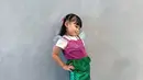 Berpose dengan tolak pinggang, rambut Ameena Atta ditata dengan halt ponytail berpitan dan poni depan [@aurel.hermansyah]