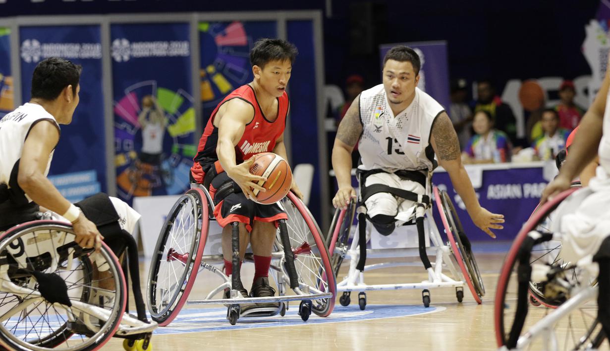 Pebasket Indonesia, Donald Santoso, berusaha melewati pebasket Thailand pada Asian Para Games di Hall Basket, Jakarta, Rabu (10/10/2018). Indonesia kalah 10-62 dari Thailand. (Bola.com/M Iqbal Ichsan)