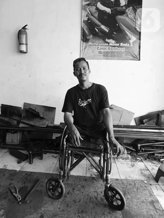 Penyandang disabilitas Catur Bambang (45) berpose di bengkel pembuatan sepeda motor roda tiga miliknya, Jalan Wijaya Kusuma, Ciputat Timur, Tangerang Selatan, Banten, Selasa (5/11/2019). Catur mengalami cacat fisik akibat kecelakaan kerja. (merdeka.com/Arie Basuki)