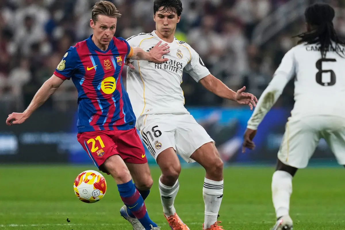 Pemain Barcelona Frenkie de Jong (kiri) berduel memperebutkan bola dengan pemain Real Madrid Gonzalo Garcia
