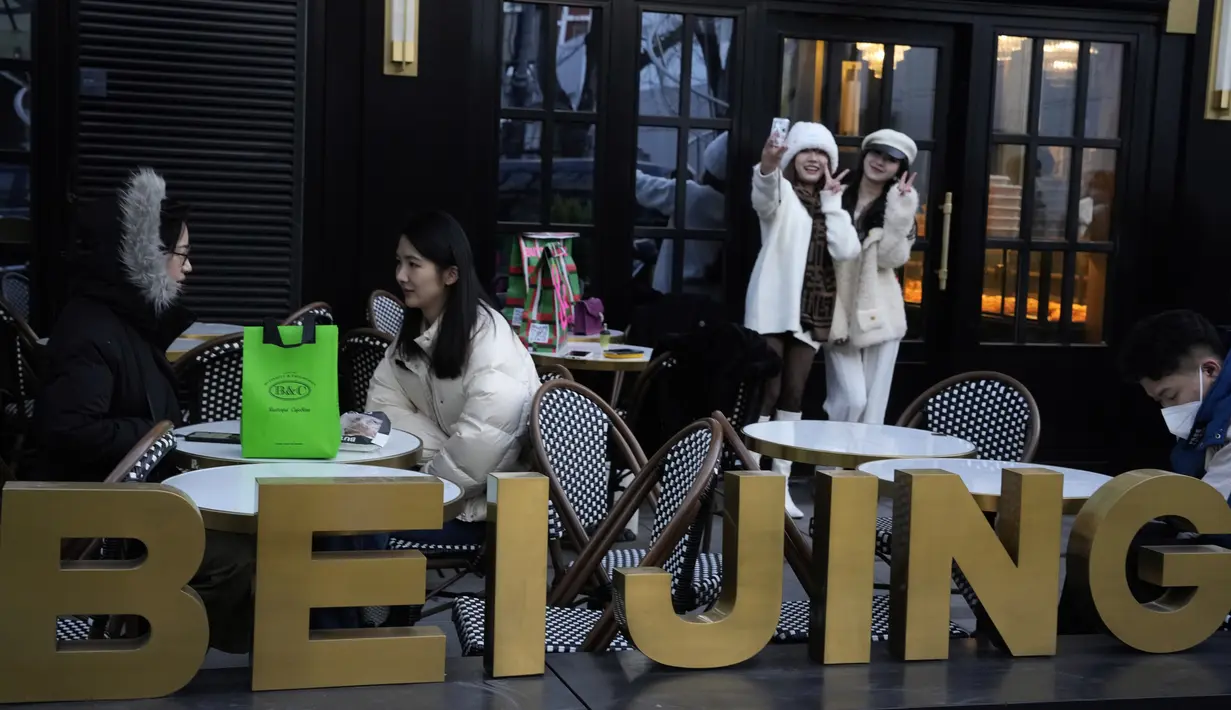 <p>Warga berswafoto di luar toko roti populer di Beijing, China, Rabu (28/12/2022). China mengatakan akan melanjutkan penerbitan paspor untuk pariwisata dalam langkah besar lainnya dari kontrol anti-virus yang mengisolasi negara itu selama hampir tiga tahun, menyiapkan potensi banjir orang China yang pergi ke luar negeri untuk liburan Tahun Baru Imlek bulan depan. (AP Photo/Ng Han Guan)</p>