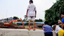 Bocah-bocah di sekitar Sungai Ciliwung melihat proses pengerukan di Sungai Ciliwung, Jakarta, Senin (16/6/2014) (Liputan6.com/Faizal Fanani)