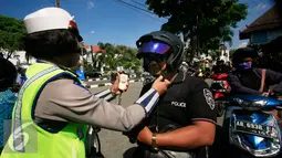 Seorang Polwan mengancingkan tali helm pada operasi lalu lintas di Abu Bakar Ali,Yogyakarta, (19/5). Operasi ini untuk menekan angka kecelakaan, petugas memberikan surat tilang di tempat kepada pelanggar lalu lintas. (Liputan6.com/Boy Harjanto)