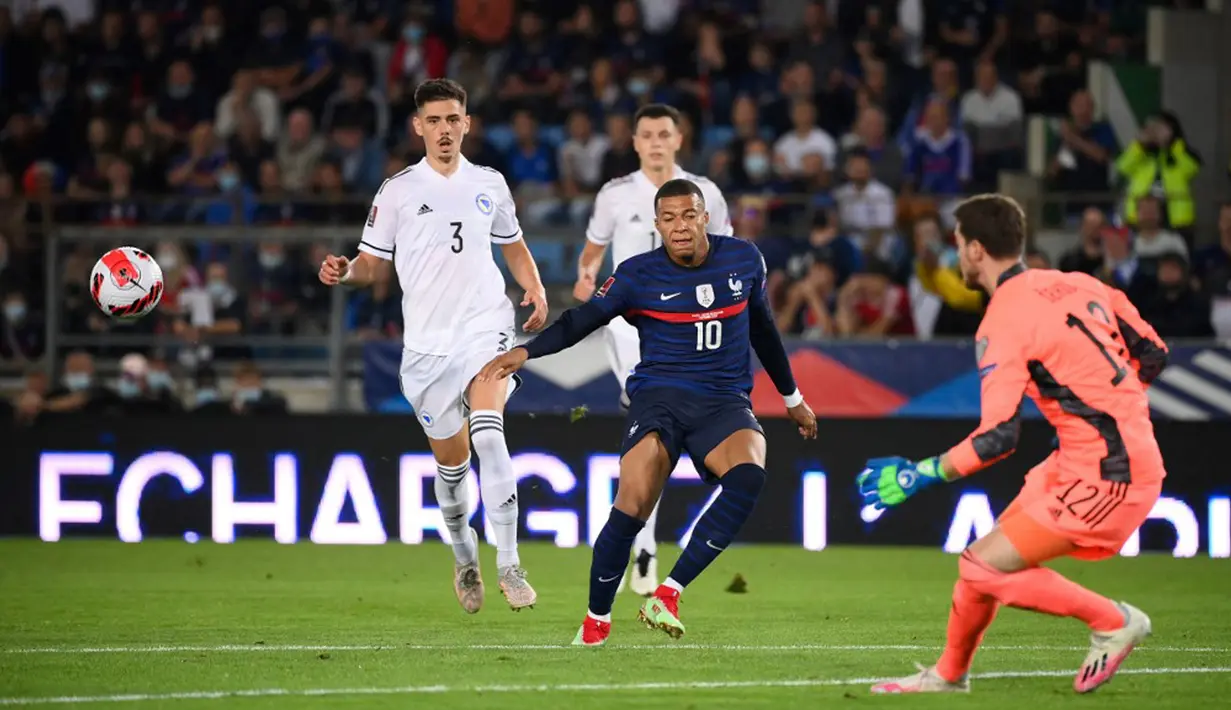 Pemain Prancis Kylian Mbappe (tengah) menatap bola saat berebut bola dengan pemain Bosnia-Herzegovina Dennis Hadzikadunic (kiri) dan kiper Ibrahim Sehic (kanan) pada pertandingan Grup D kualifikasi Piala Dunia 2022 di Stadion Meineau, Strasbourg, Prancis, Rabu (1/9/2021). (FRANCK FIFE/AFP)