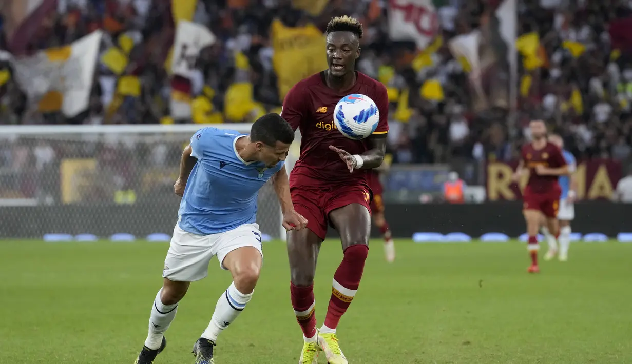Penyerang AS Roma, Tammy Abraham berebut bola dengan pemain Lazio, Gonzalo Escalante pada pertandingan lanjutan Liga Serie A Italia di Stadion Olimpiade Roma, Senin (27/9/2021). Dengan kemenangan ini Lazio kini naik ke posisi enam dengan 11 poin dari enam laga. (AP  Photo/Andrew Medichini)