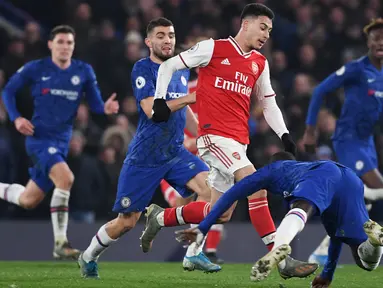 Striker Arsenal, Gabriel Martinelli, berebut bola dengan pemain Chelsea pada laga Premier League pekan ke-24 di Stamford Bridge, London, Rabu (22/1). Arsenal tahan imbang Chelsea 2-2. (AFP/Daniel Leal-Olivas)