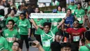 Peserta menunjukkan tulisan saat sampai di garis finis dalam Lomba lari MILO Jakarta International 10K 2017, Jakarta, Minggu (23/7). MILO Jakarta International 10K 2017 melombakan tiga kategori 10K, 5K dan Family Run 1,7K. (Liputan6.com/Faizal Fanani)