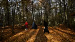 Orang-orang berjalan di Taman Nasional Yedigoller di distrik Bolu, pada 9 November 2021. Turki merupakan sebuah negara dengan tujuan wisata yang populer di musim gugur, diantaranya adalah Taman Nasional Yedigöller. (Ozan KOSE / AFP)