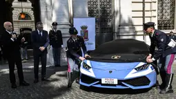 Kepolisian Italia mendapatkan Lamborghini Huracan LP 610-4 sebagai mobil patroli terbaru dalam sebuah seremoni di Kementerian Dalam Negeri di Roma, 30 Maret 2017. Huracan ini akan bertugas untuk keperluan patroli jalan tol di Bologna. (Andreas SOLARO/AFP)