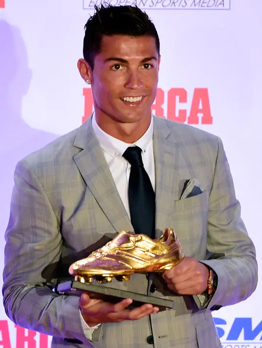Penyerang Real Madrid, Cristiano Ronaldo berpose dengan sepatu emas keempatnya di Madrid, Spanyol, Selasa (13/10). Ronaldo kembali menerima Golden Boot dan merupakan gelar keempat bagi dirinya setelah mencetak 48 gol. (AFP PHOTO/JAVIER Soriano)