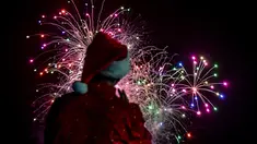 Seorang pria mengenakan kostum santa melihat kembang api selama parade Natal di Panama City (16/12). Warga Panama tengah mempersiapkan diri menyambut datangnya Natal 2018 yang jatuh pada tanggal 25 Desember. (AFP Photo/Luis Acosta)