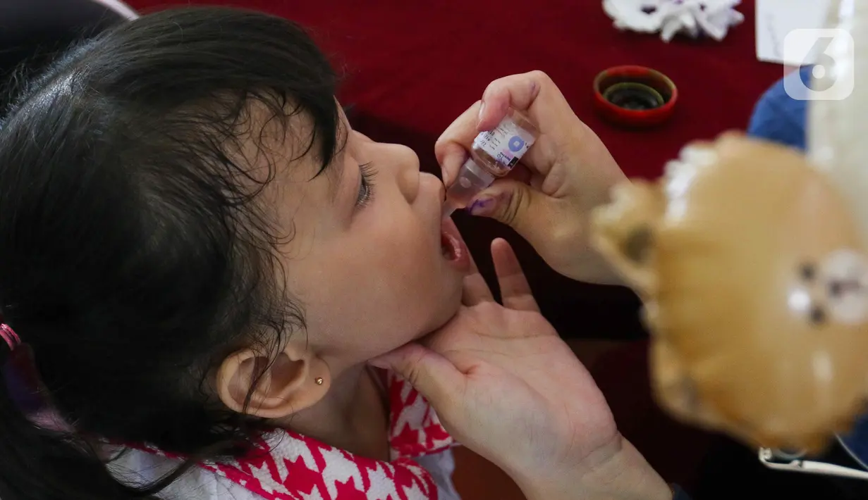 Petugas memberikan vaksin polio tetes kepada seorang anak saat berlangsungnya pekan imuniasasi nasional di RPTRA Kenanga, Cideng, Jakarta, Selasa (23/7/2024). (Liputan6.com/Herman Zakharia)