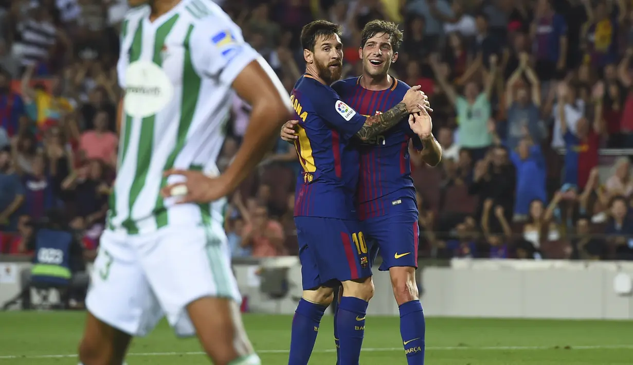 Lionel Messi dan Sergi Roberto (kanan) merayakan gol ke gawang Real Betis pada  laga La Liga Spanyol di Camp Nou stadium, Barcelona, (20/8/2017). Barcelona menang 2-0. (AFP/Josep Lago)