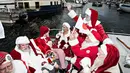 Sinterklas dari penjuru dunia menaiki kapal saat melakukan tur di pelabuhan Kopenhagen, Denmark, Senin (24/7). Kongres Dunia Sinterklas yang dilaksanakan setiap tahun itu menjadi ajang silaturahmi bagi para Sinterklas. (Tobias Nicolai/Ritzau Foto via AP)