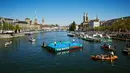 Petenis asal Swiss, Roger Federer (kiri) bertanding melawan petenis asal Inggris, Andy Murray di lapangan kecil di atas sungai Kota Zurich, Senin (10/4). Kedua petenis itu terlibat dalam program amal The Match For Africa 3. (Michael Buholzer/AFP)