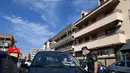 Seorang petugas polisi setempat memeriksa dokumen pengemudi di pos pemeriksaan lalu lintas untuk mengendalikan pergerakan orang-orang di kota Fuenlabrada yang tertutup sebagian, di wilayah Madrid (22/9/2020). Penguncian dilakukan akibat infeksi virus melonjak. (AFP/Oscar Del Pozo)