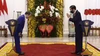 Perdana Menteri Jepang Yoshihide Suga (kiri) dan Presiden Joko Widodo (Jokowi) saling menyapa saat konferensi pers bersama di Istana Bogor, Selasa (20/10/2020). Lawatan kenegaraan tersebut dalam rangka meningkatkan hubungan bilateral antar kedua negara. (INDONESIAN PRESIDENTIAL PALACE / AFP)