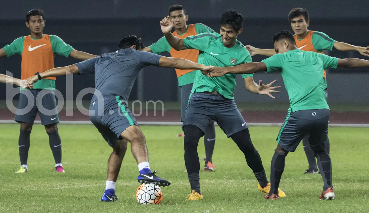 Pemain Timnas Indonesia, Hanif Sjahbandi, berebut bola dengan asissten pelatih, Bima Sakti saat latihan. Uji coba ini menjadi laga terakhir Timnas U-22 sebelum berangkat untuk pelatihan panjang di Spanyol. (Bola.com/Vitalis Yogi Trisna)