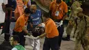 Sejumlah petugas membawa korban dari sekolah samba Unidos da Tijuca yang terjatuh saat mengikuti Rio Carnival di Rio de Janeiro, Brasil (28/2). (AFP PHOTO/Vanderlei Almeida)